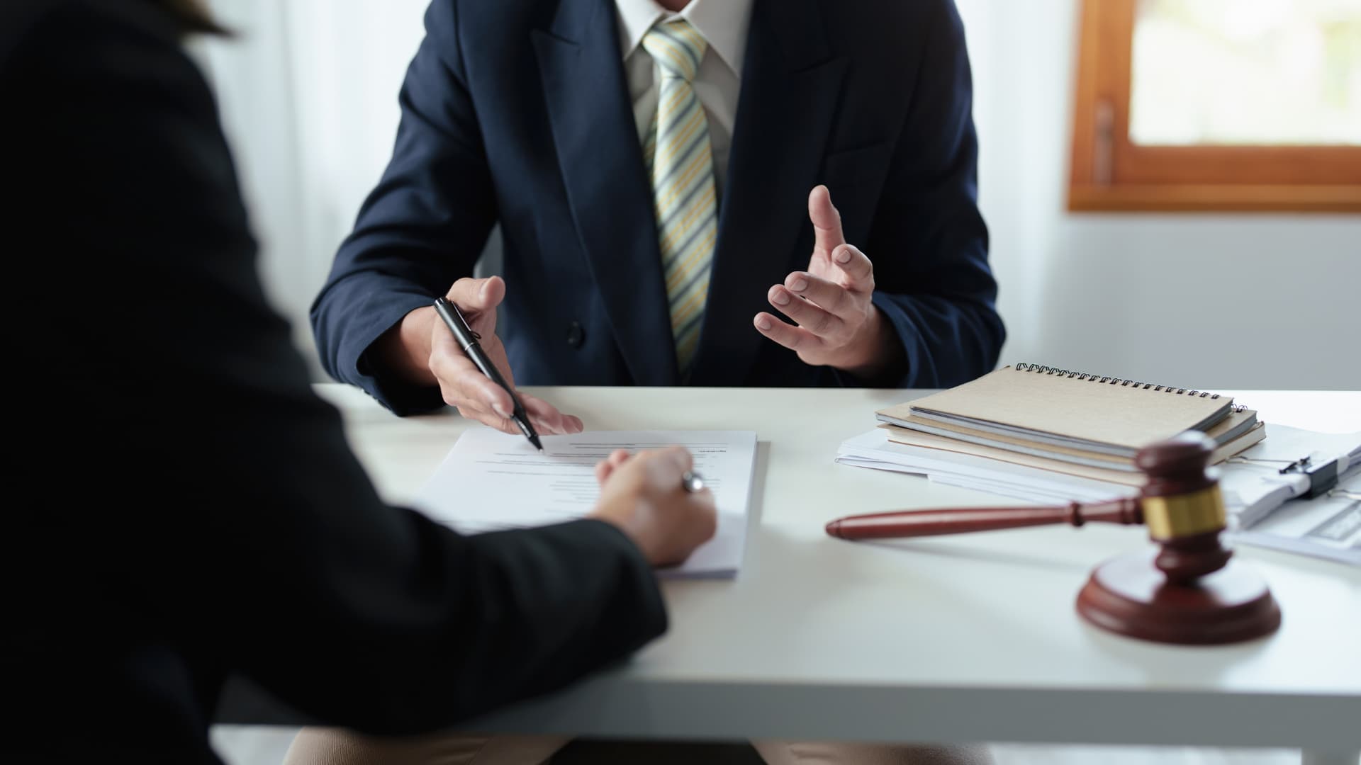 An image of an attorney meeting with a client in their office. 