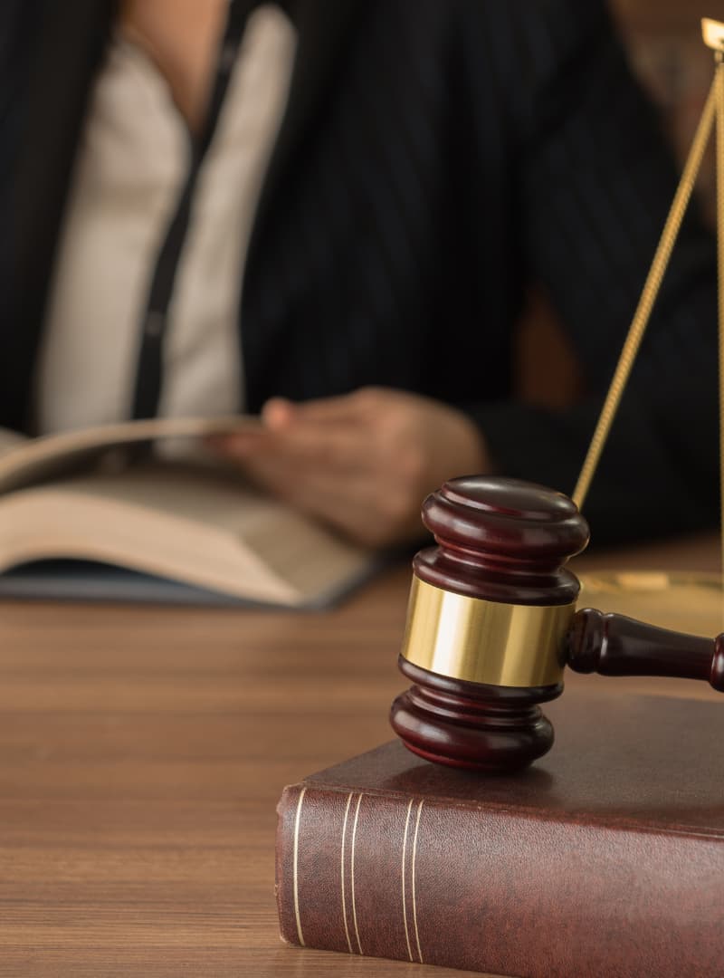 An image of legal scales and a gavel on a desk of an aottrney